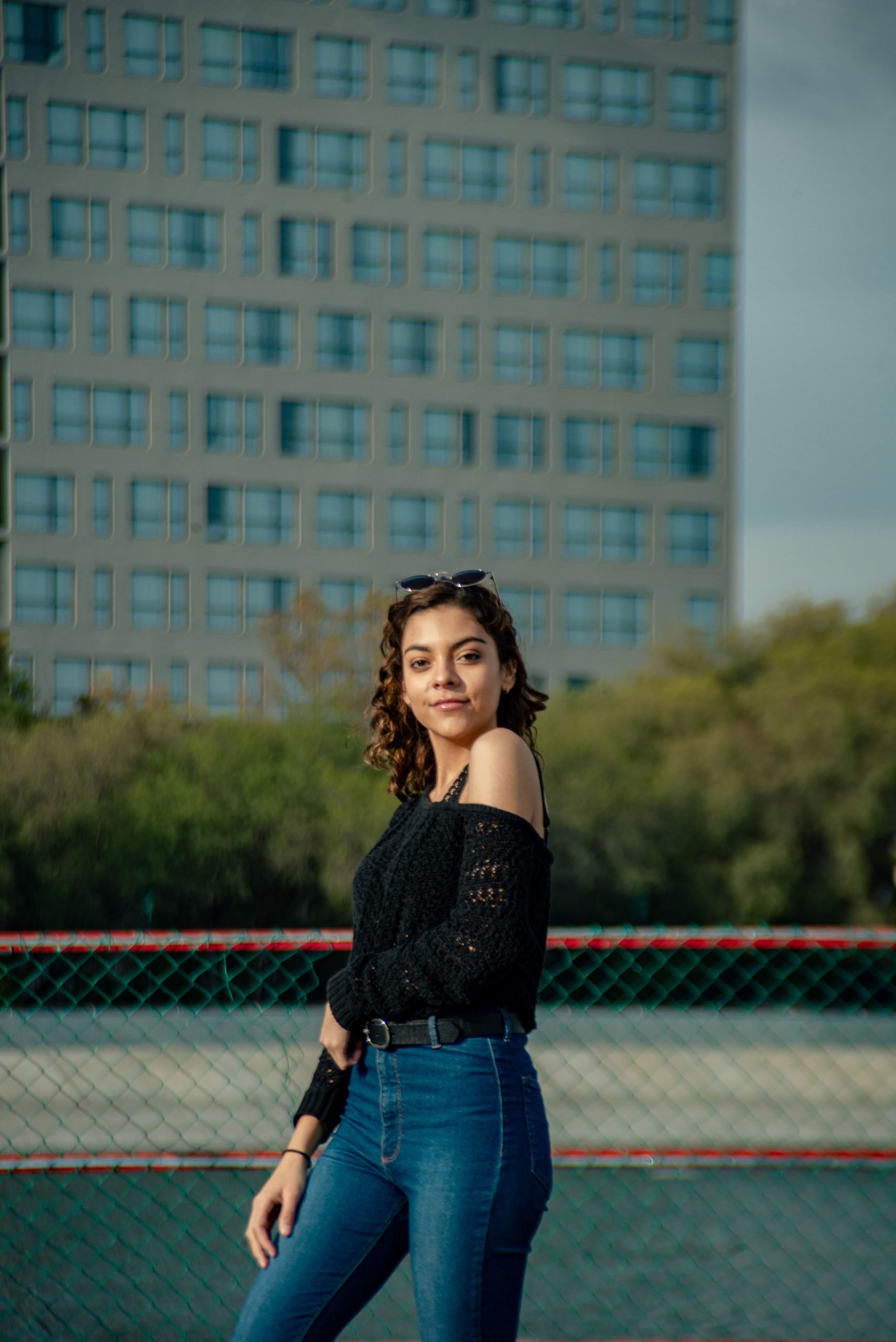 Woman wearing a black lace blouse and jeans outdoors
