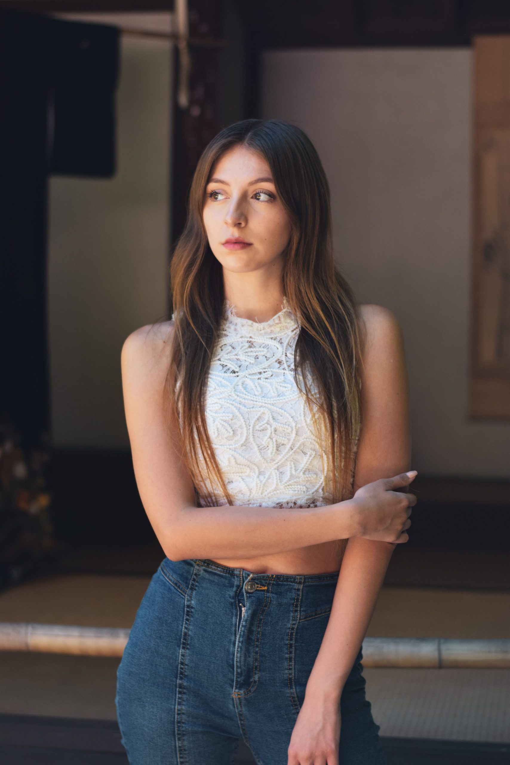 Woman wearing an embroidered white blouse with jeans indoors