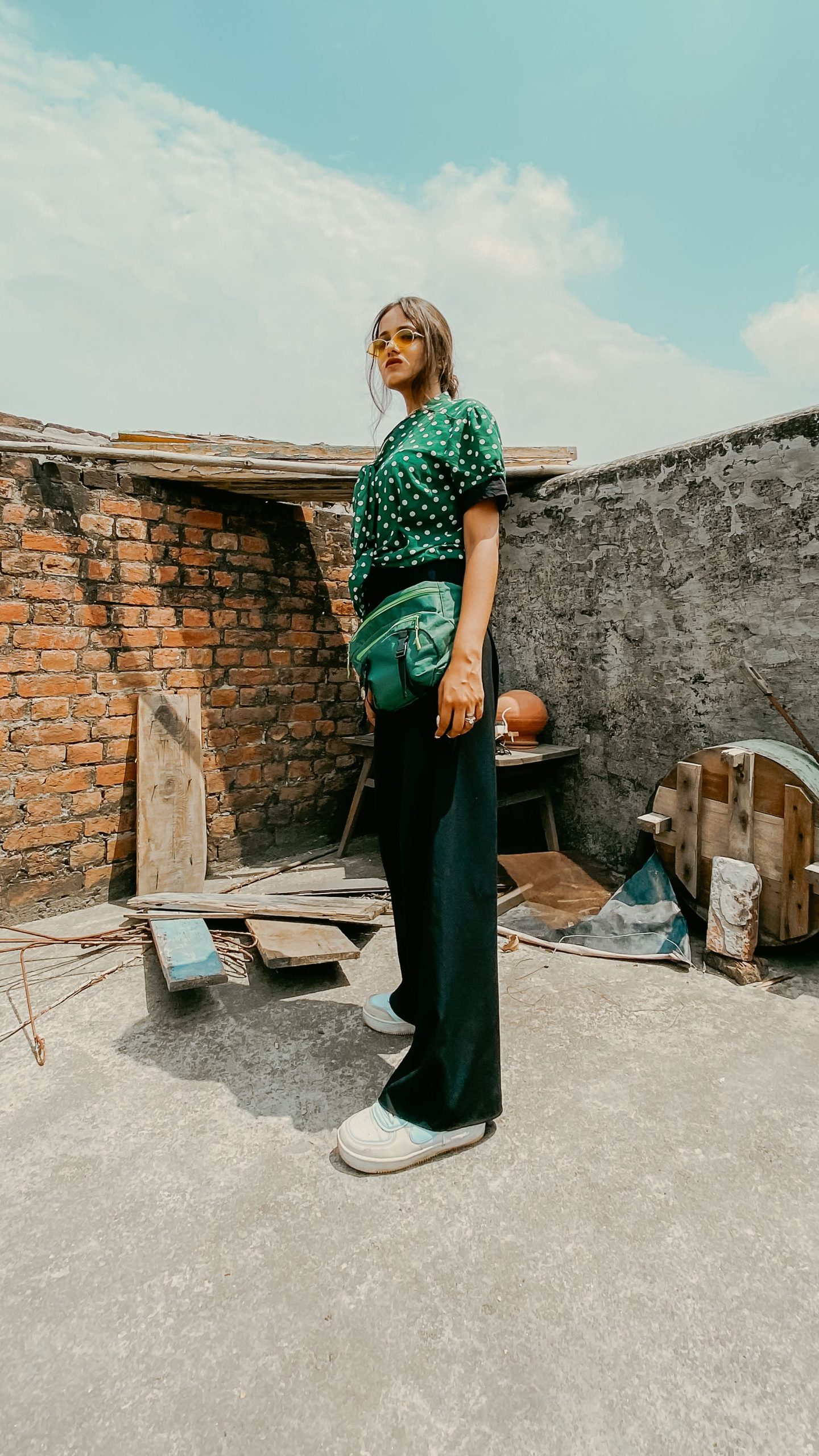 Woman wearing a polka dot blouse during an outdoor rooftop fashion shoot